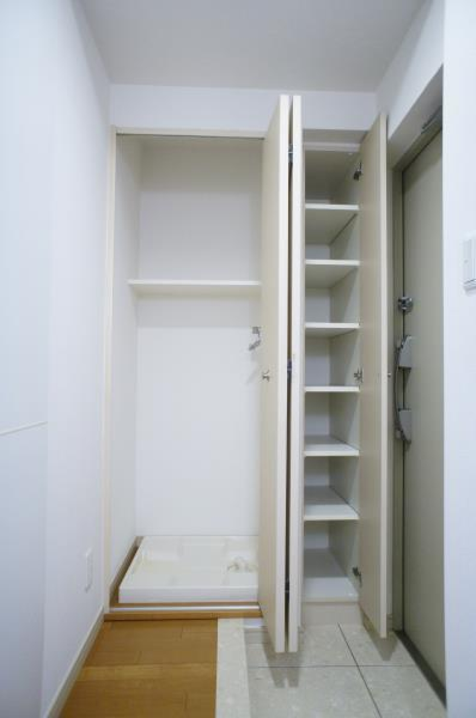 向かって左が扉付き洗濯機置き場、右が縦長シューズボックス