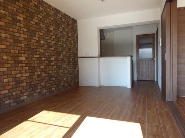 LDKは10.8帖。レンガ風のシックな壁紙が印象的。