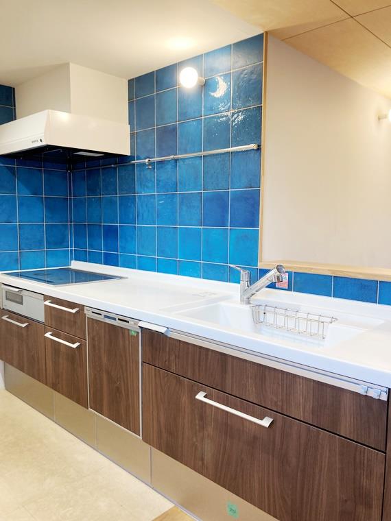 瑠璃色の大判タイルが元気の出る大きなシステムキッチン