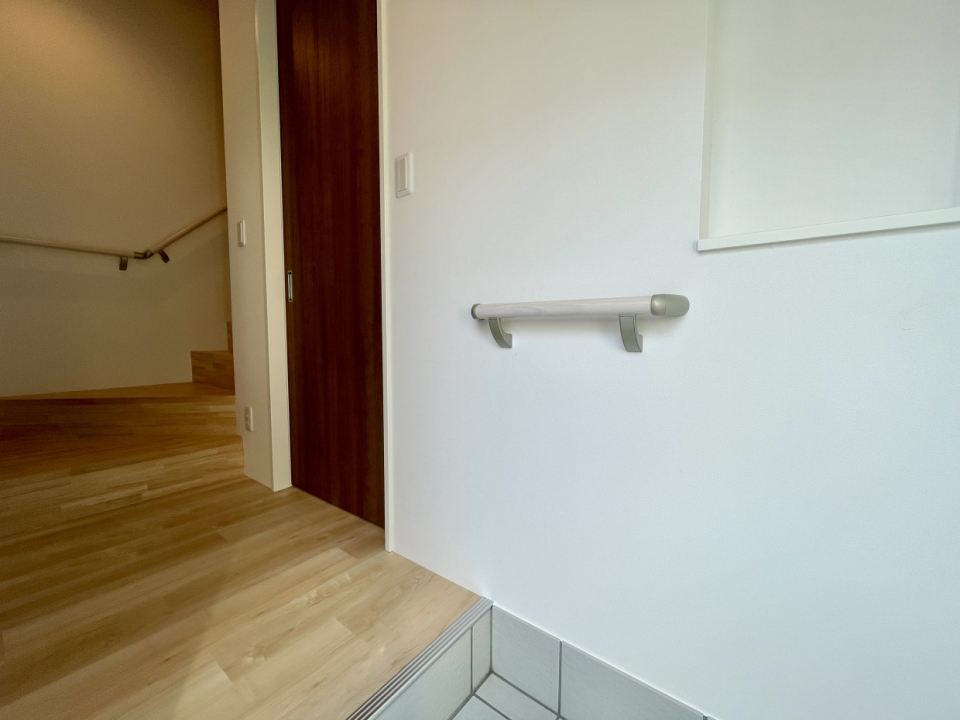 玄関のニッチにぜひ家族写真を！手すりがあるので靴の脱ぎ履きもラクラク。