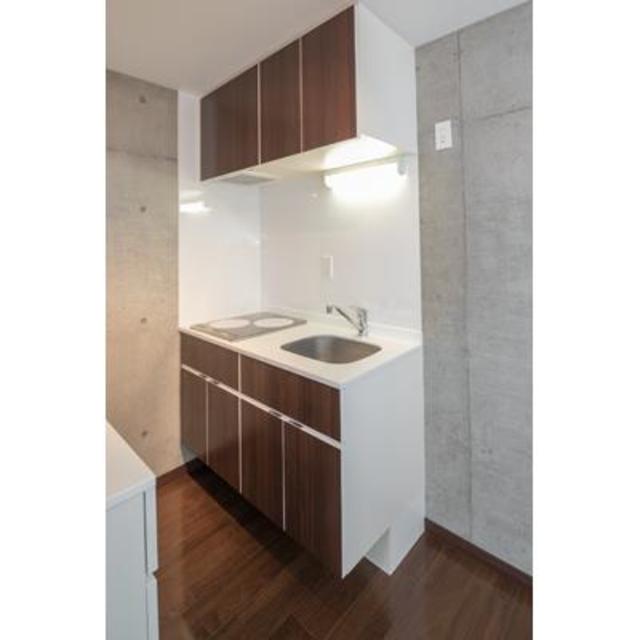 キッチンも床とお揃いの濃いブラウン。※写真は同タイプ住戸です。