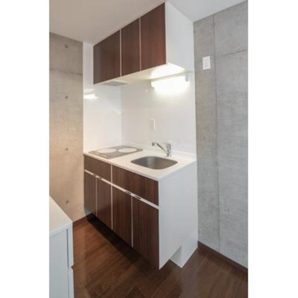 キッチンも床とお揃いの濃いブラウン。※写真は同タイプ住戸です。