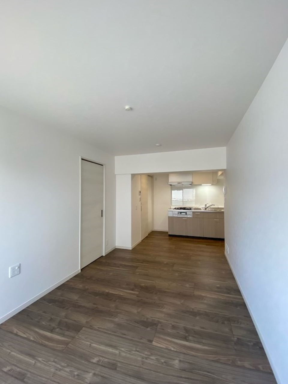 細長い居室の先に、キッチンがちらり。