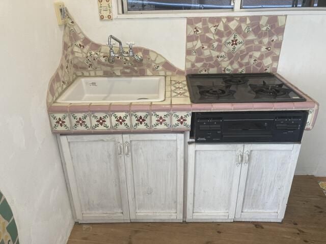 くすみピンクっぽいカラーリングが可愛い、タイル張りのキッチン。