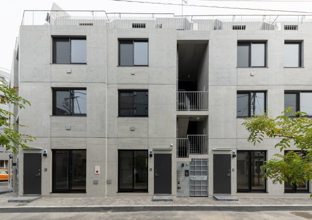 コンクリの壁に窓が並んだ可愛い建物。