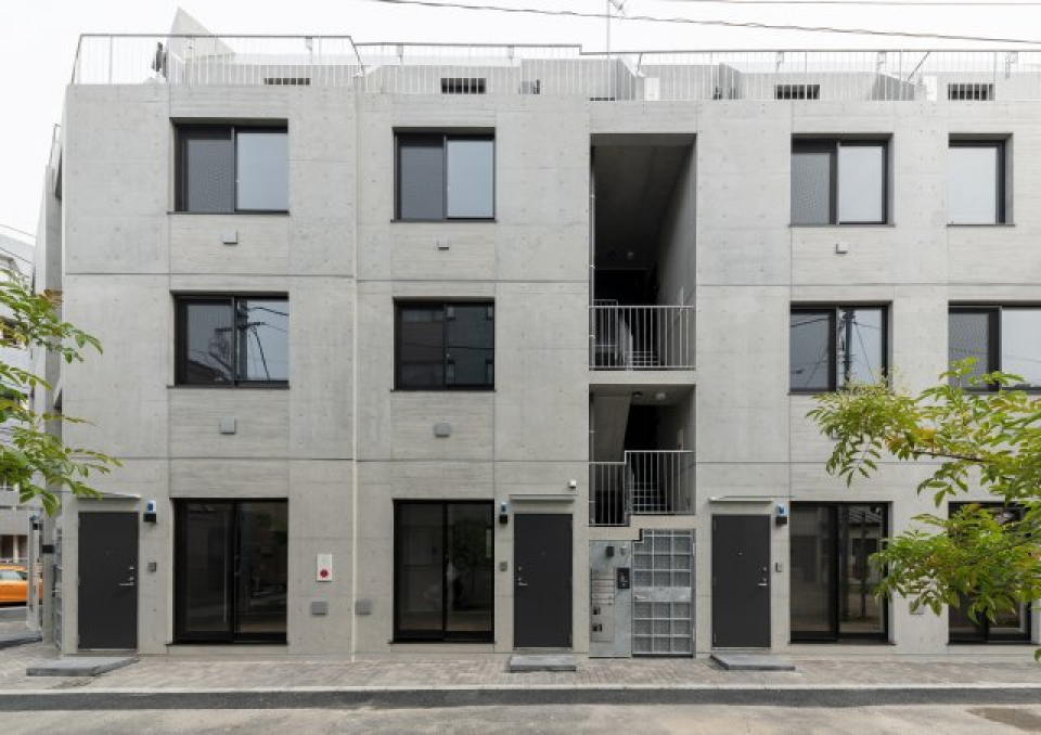 コンクリの壁に窓が並んだ可愛い建物。