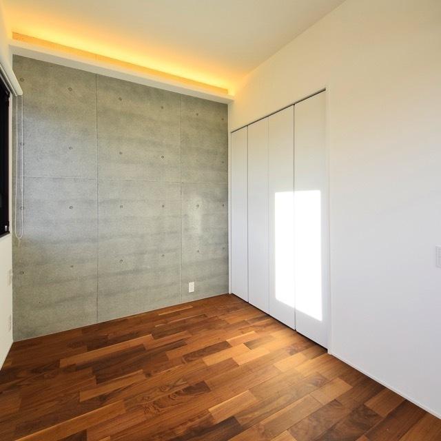 洋室の壁はコンクリがアクセントに。