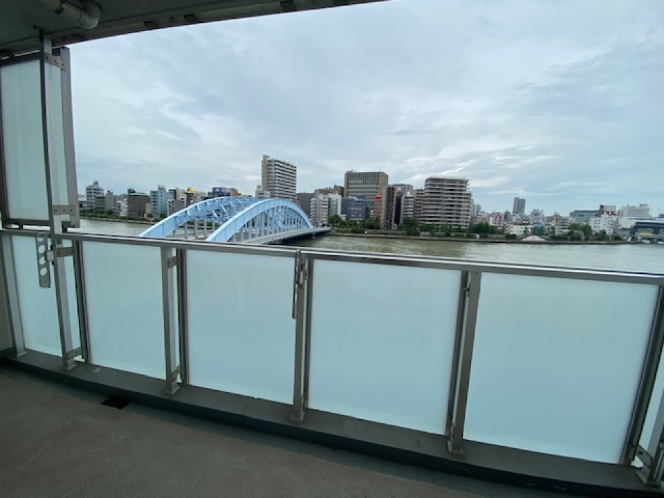 幅広のバルコニーから望む隅田川×永代橋。