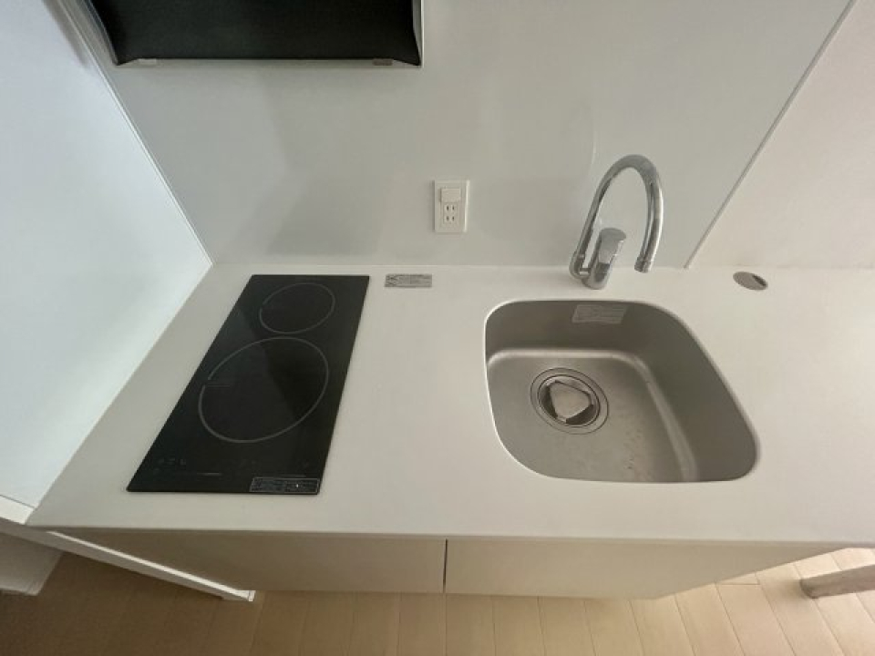 白くてシンプルなキッチン。右側に少し突き出たカウンター付きです。