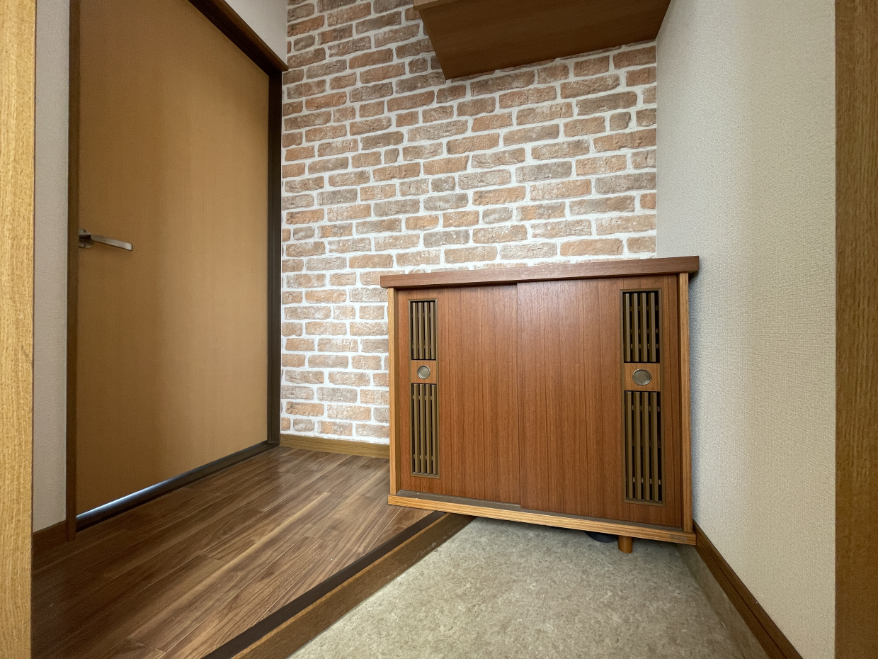 玄関はレンガチックなアクセントクロスがお出迎え。