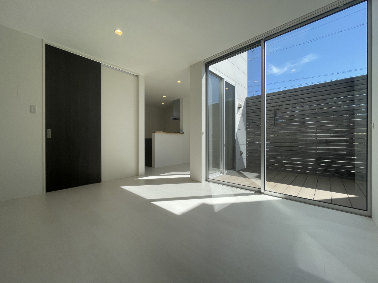 リビングスペース。大きな窓に映る青空が白い室内によく映える