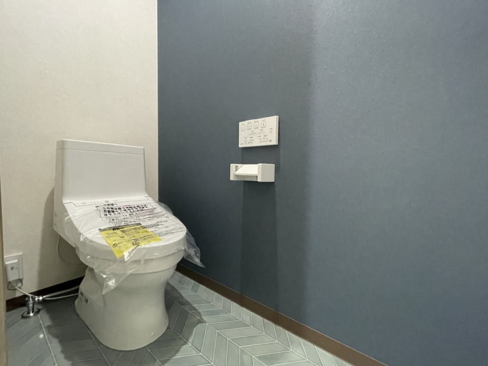 1階のトイレ。洗面所とおそろいのシックなフロア