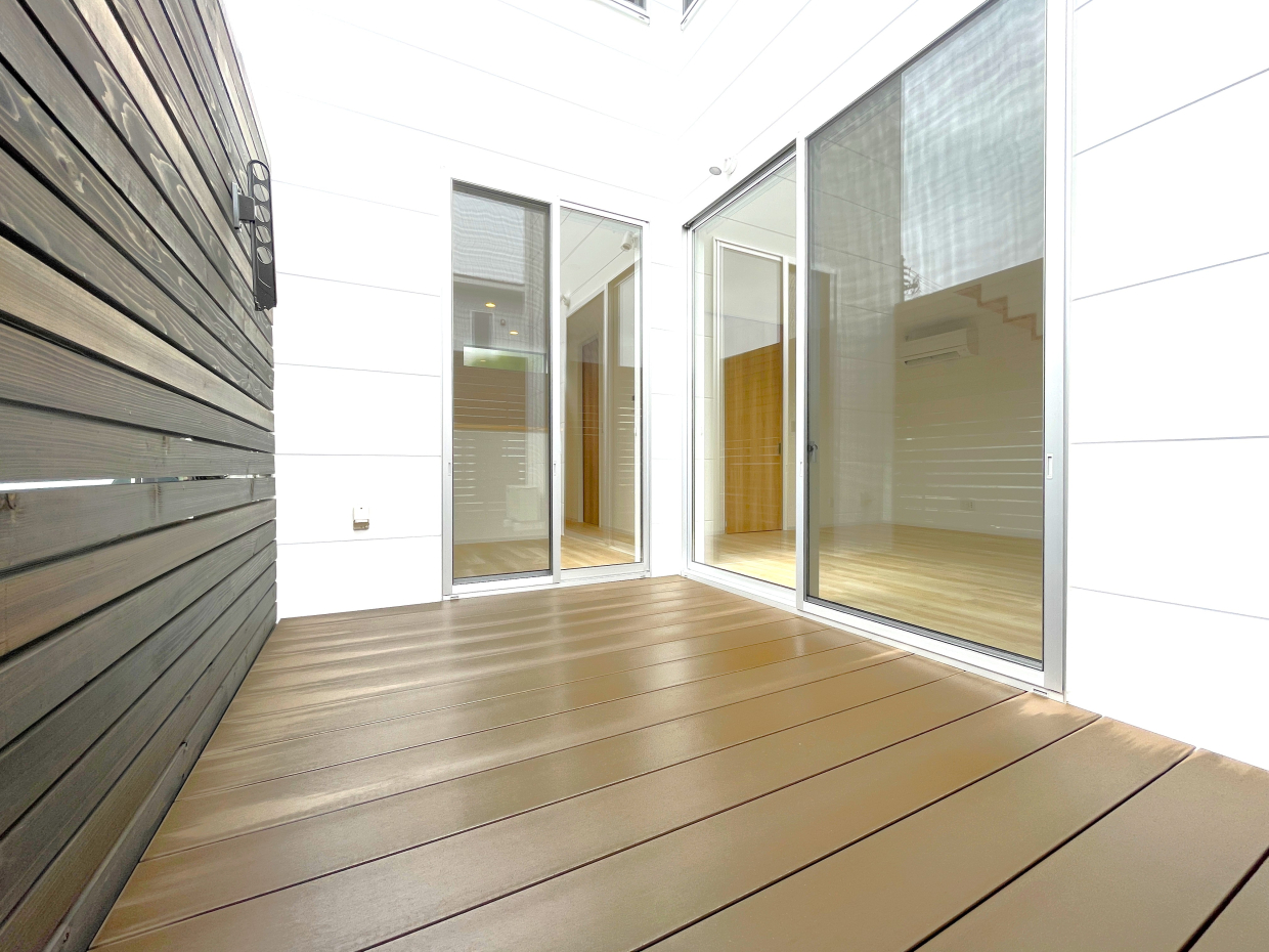 リビング側とキッチン側、2面の窓から出入りできるウッドデッキ