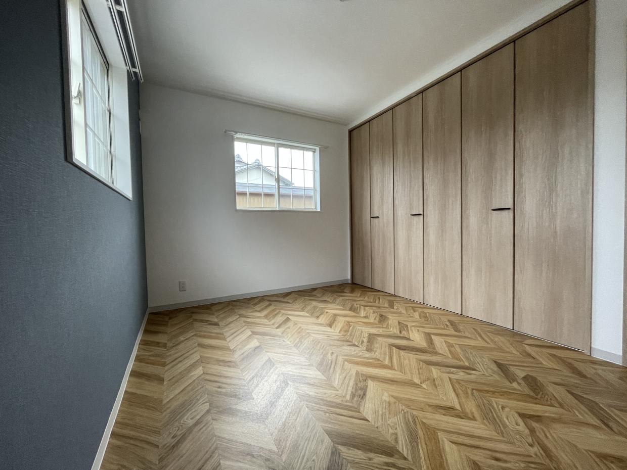 6帖の洋室②はネイビーのアクセントクロスとヘリンボーンの床の組み合わせ