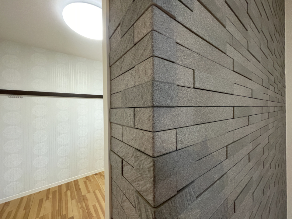 LDK東面の壁は石目調でありながらレンガのようでもありほどよい存在感