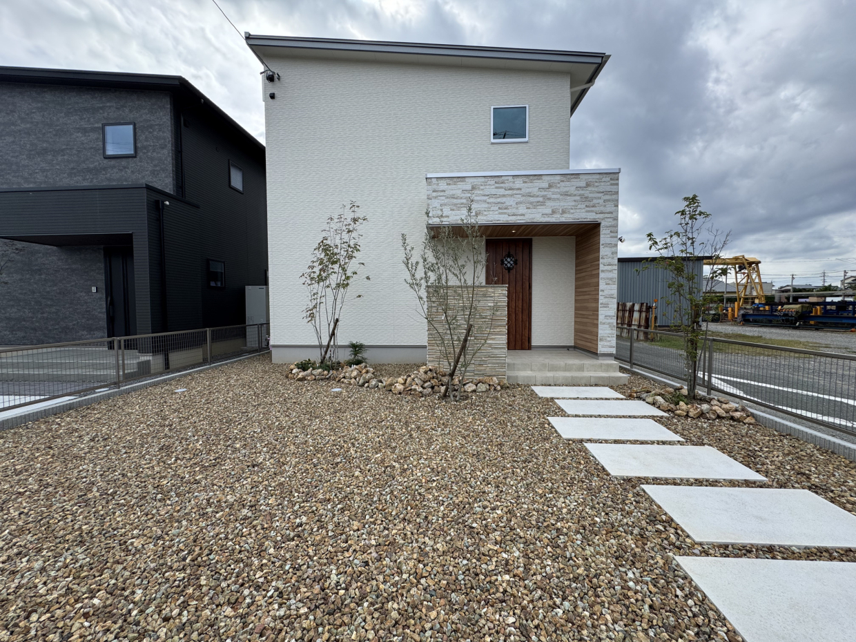 駐車場はブラウンロックの砕石が敷き詰められ、通路のみコンクリートのデザイン