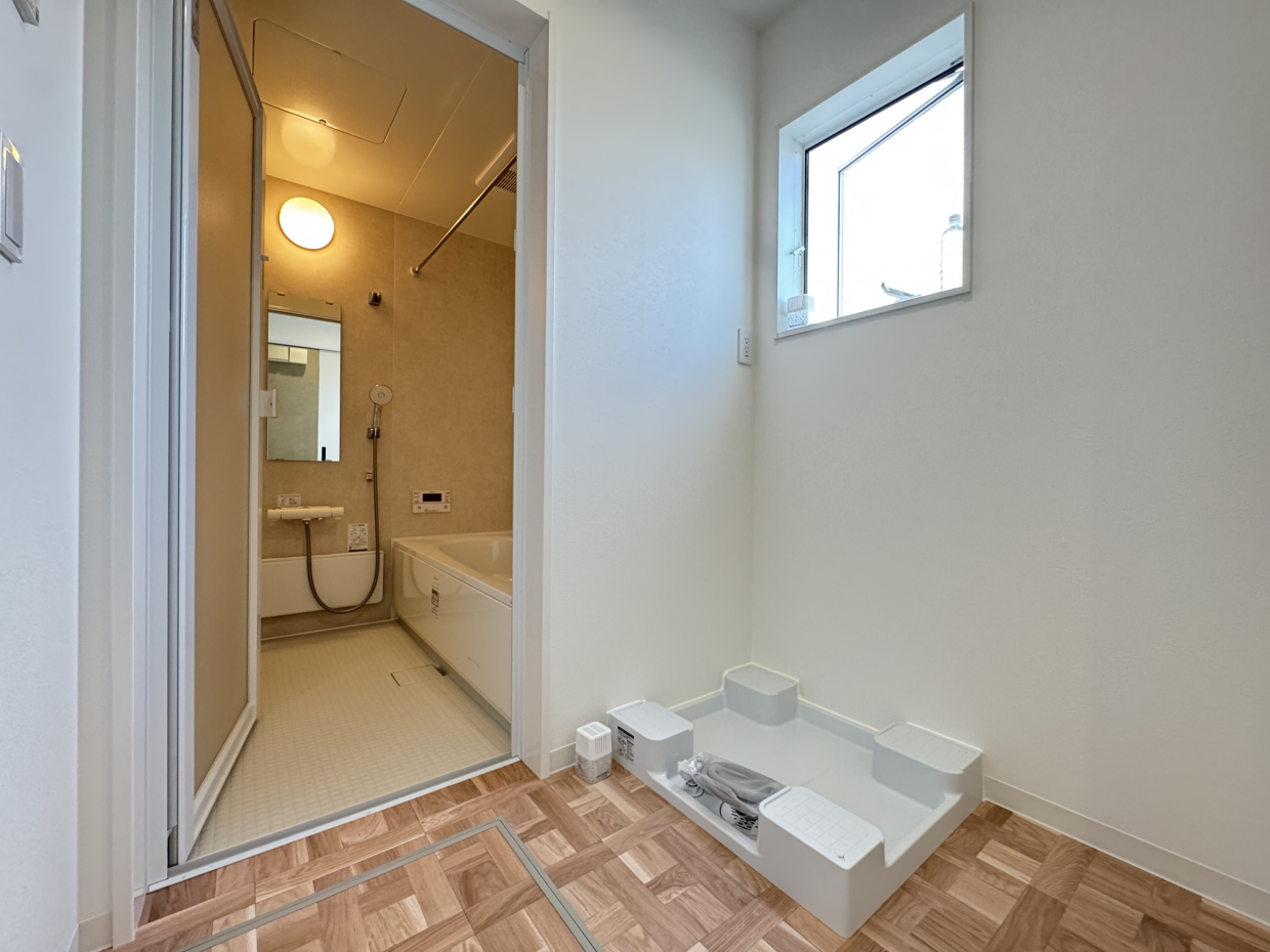 洗面スペース。洗濯機置き場の横のスペースにタオルや着替えなど必要なものを置けるスペースがある