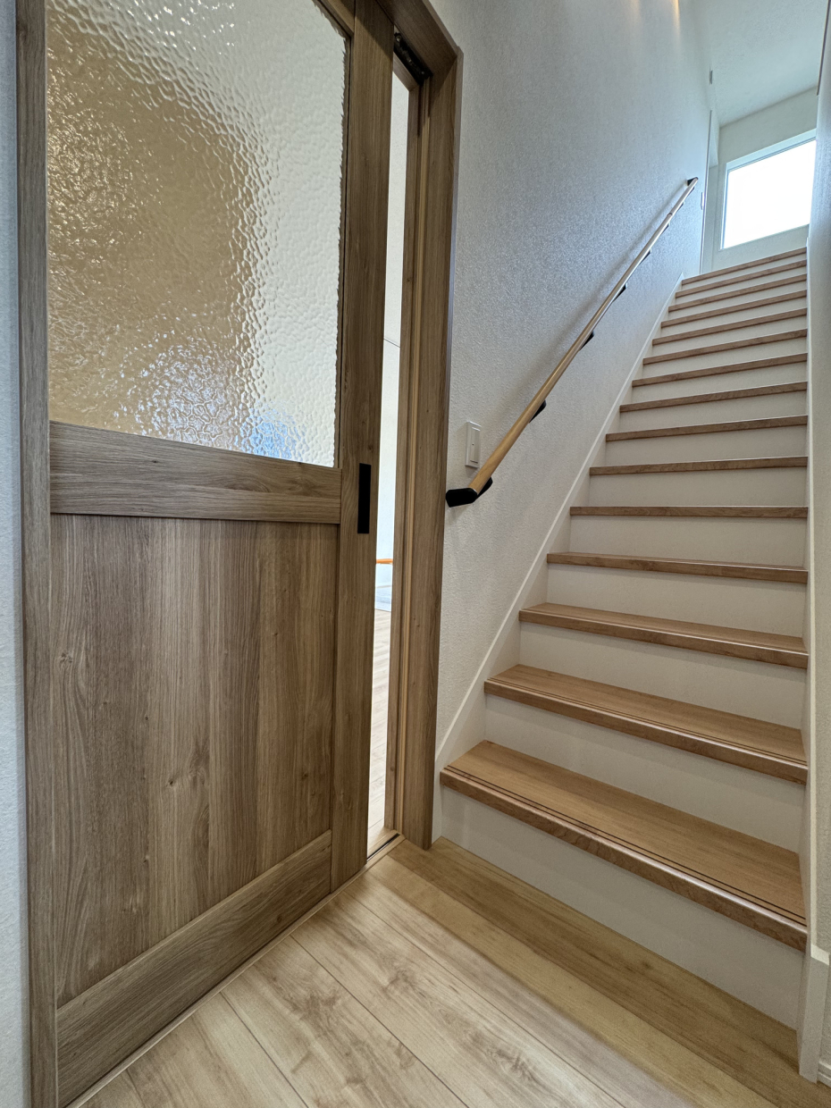 2階へ上がる階段はリビングへの扉の前