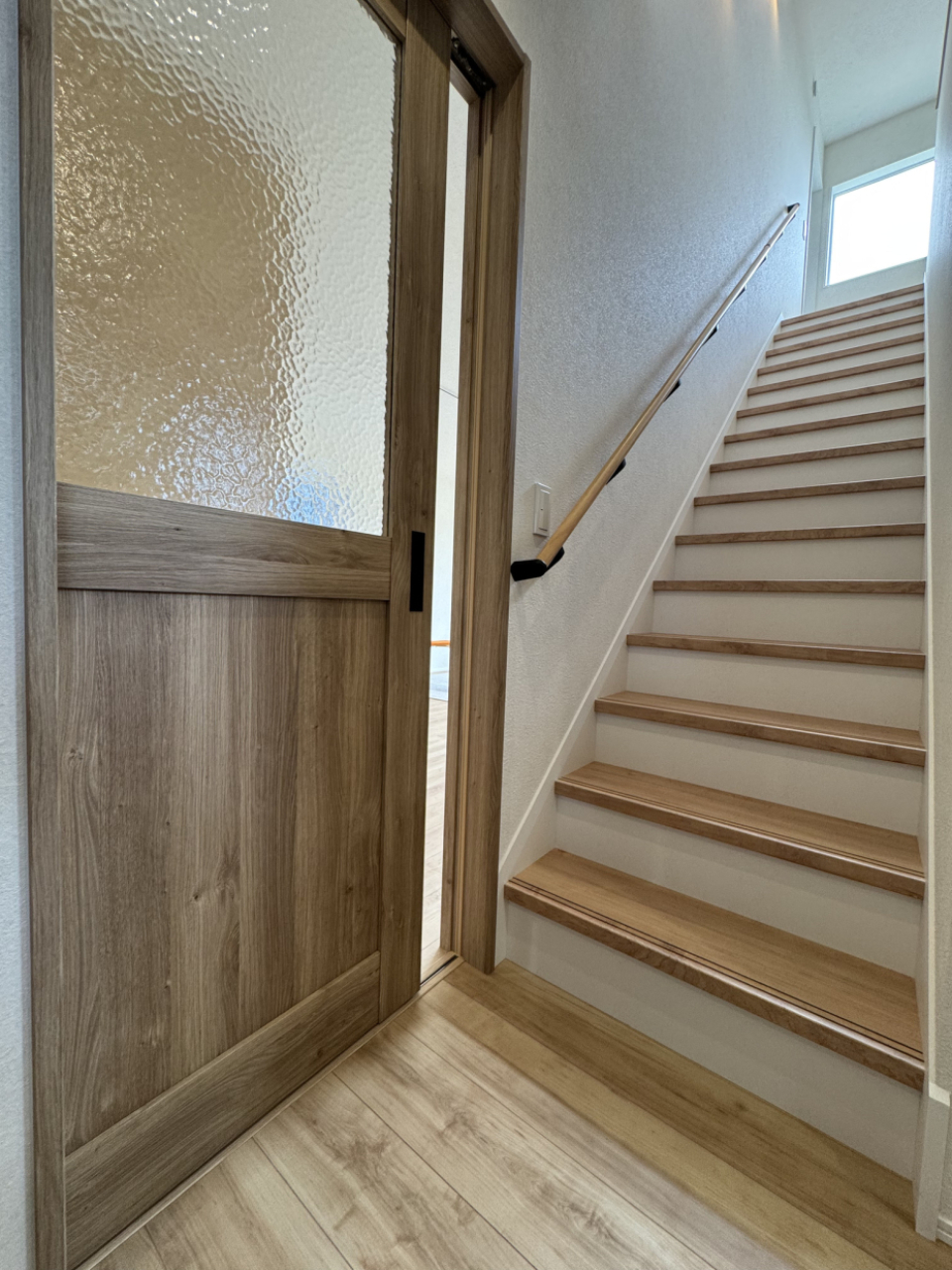 2階へ上がる階段はリビングへの扉の前