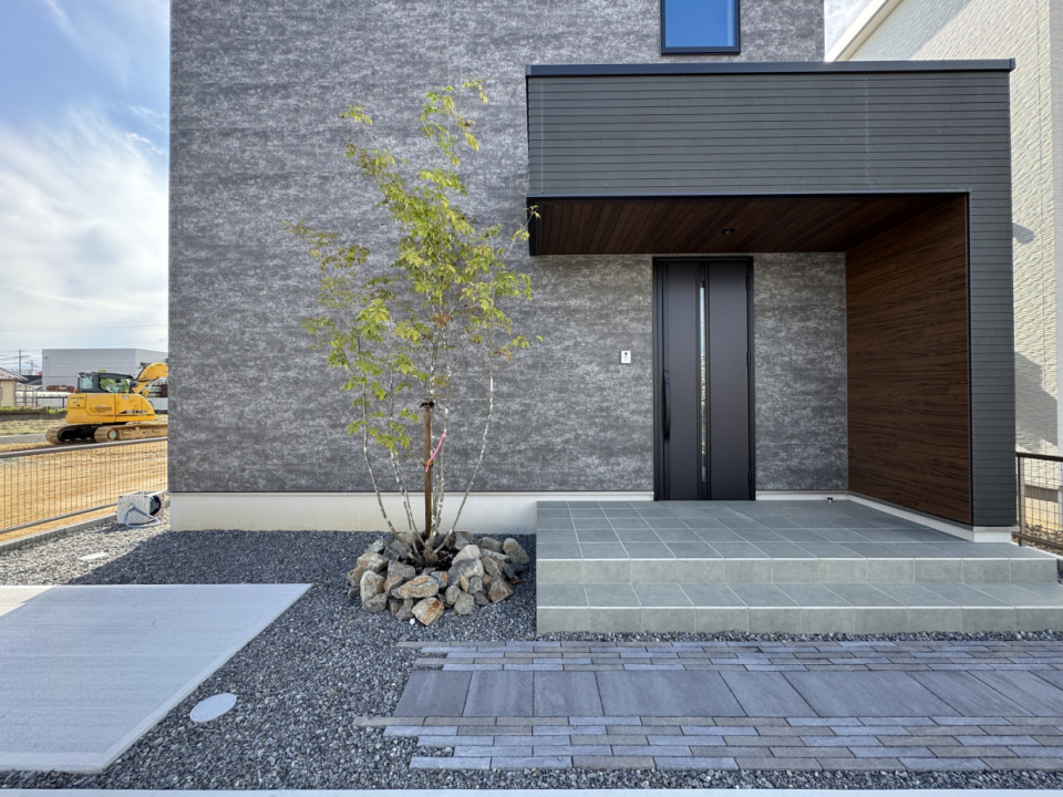 玄関先ポーチの軒天はダークブラウンの木目のサイディングで高級感を演出