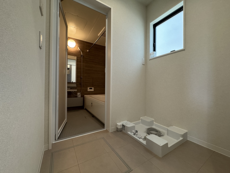 脱衣所の洗濯機置き場の横のスペースには収納を置いてタオルや着替えを保管できる