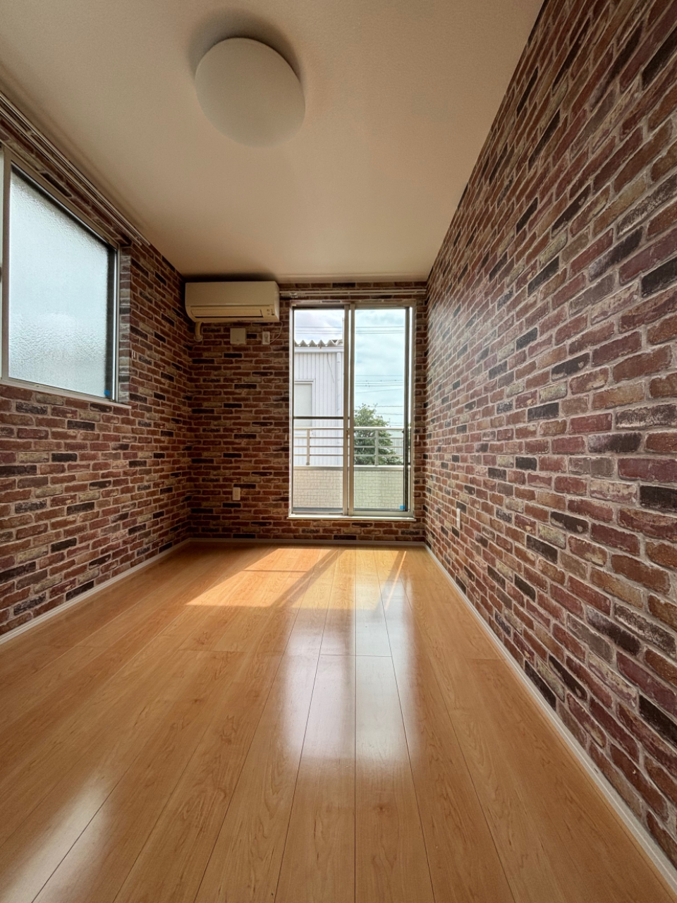 5.4帖の洋室。4面がレンガのクロス