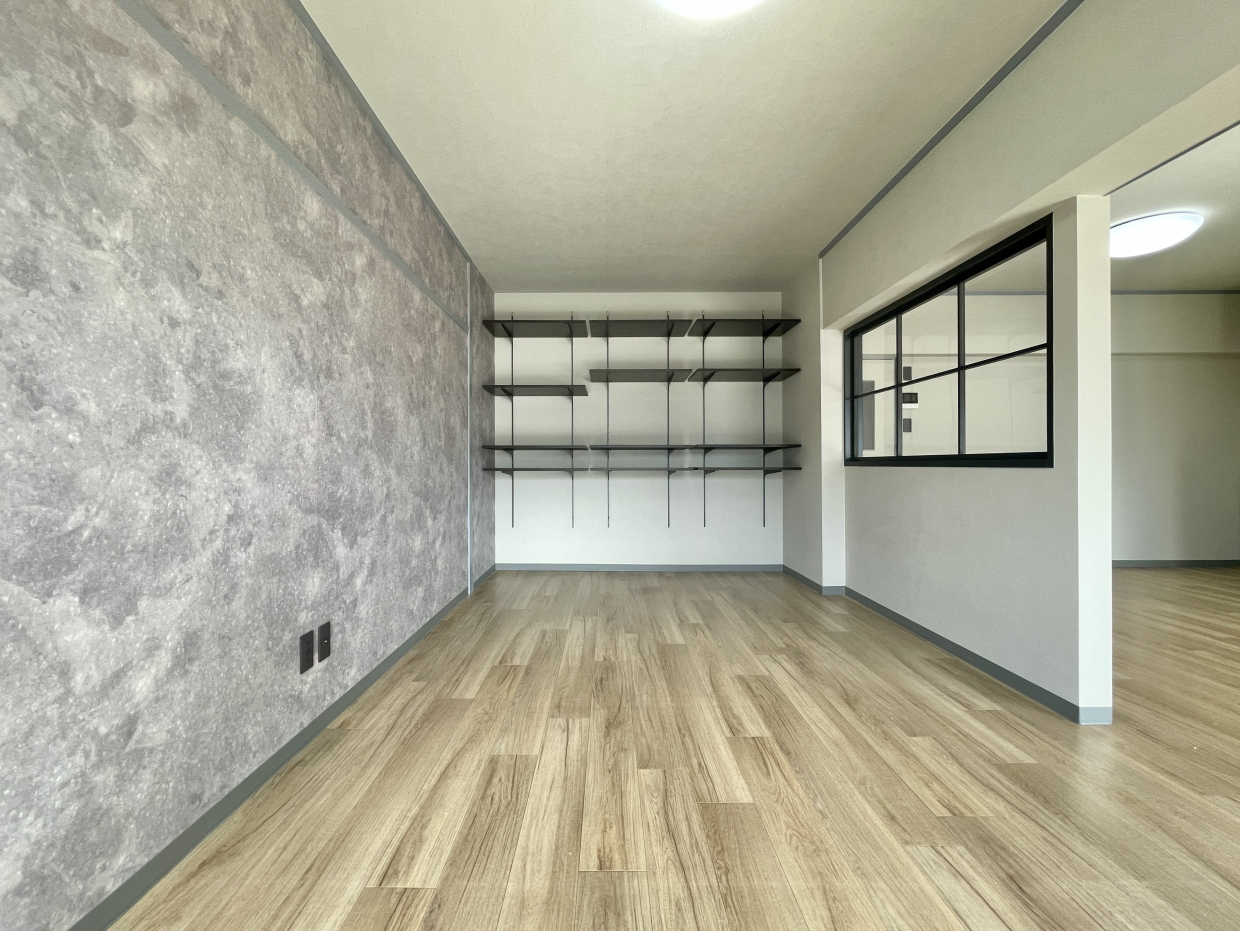 モルタル風のクロスに室内窓と可動棚の黒がモダンな雰囲気