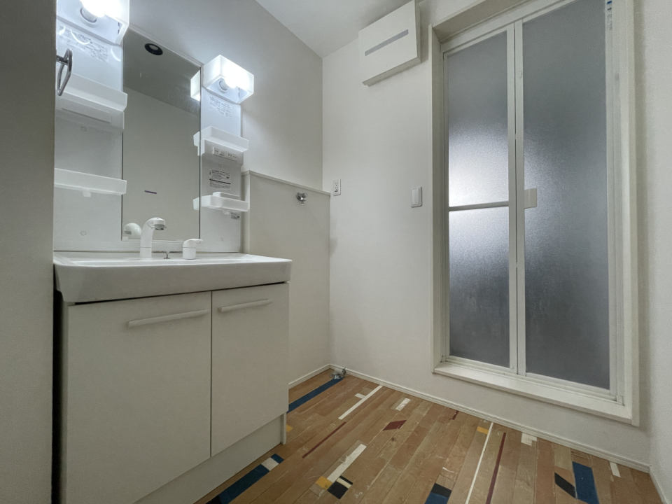 脱衣洗面所。フロアが面白い柄のフローリング